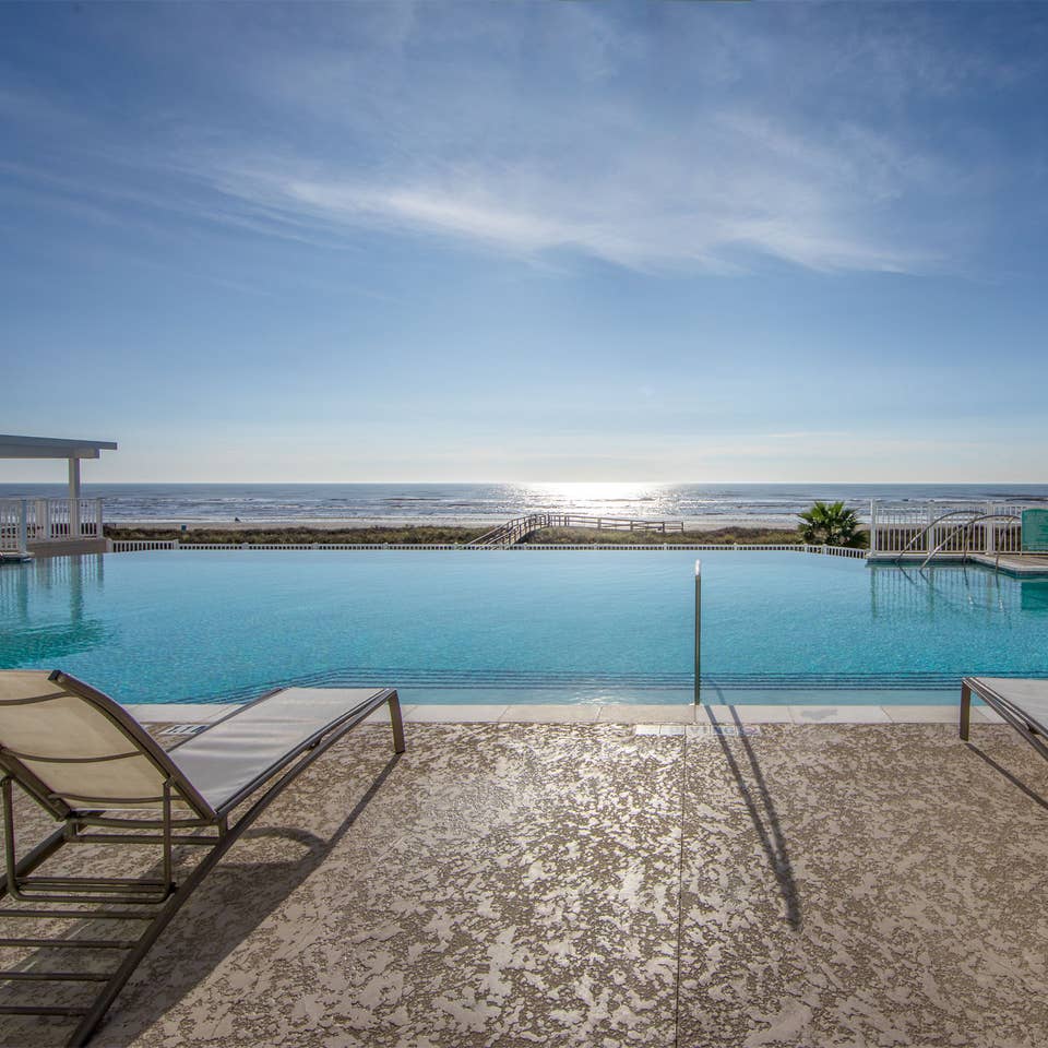 Outdoor oceanfront pool with sun chairs at Galveston Seaside Resort.