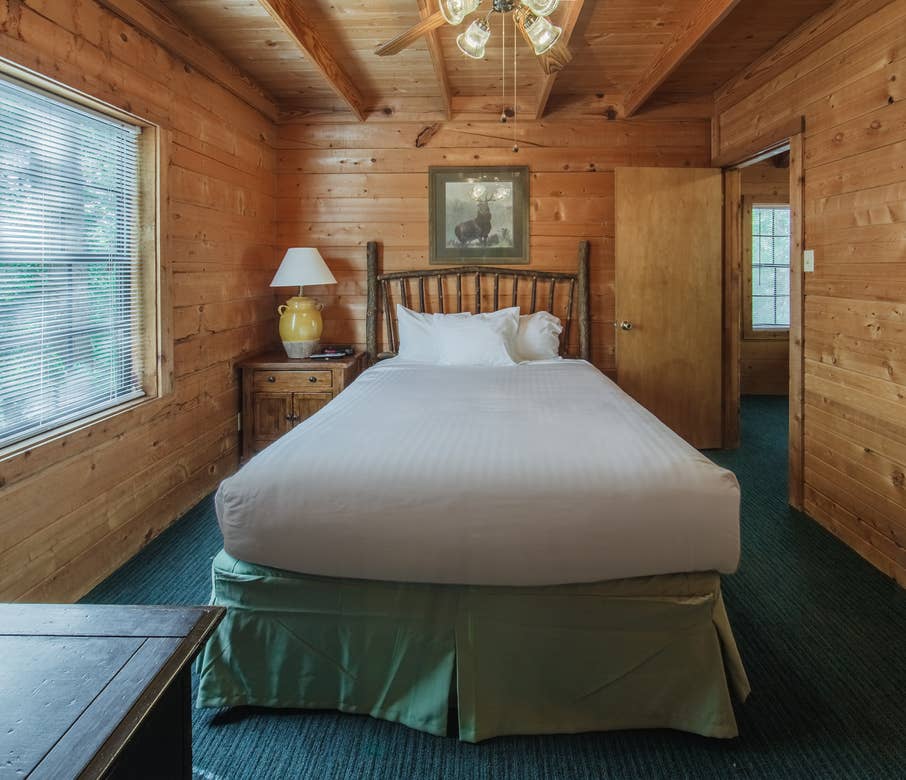Bedroom in a one-bedroom log cabin at Holly Lake Resort in Holly Lake Ranch, Texas.