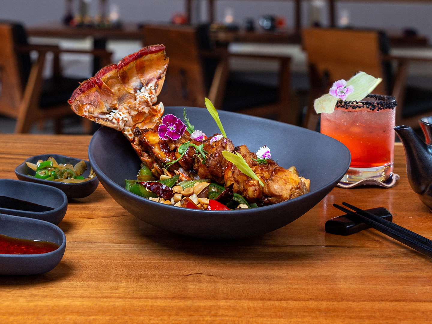 The Kinoko Restaurant, a bright colored lobster tail in a black ceramic bowl , fragranced with ginger, star anise and other spices, garnished with beautiful colorful seasonal flowers at The Royal Haciendas, in Playa del Carmen, Mexico 