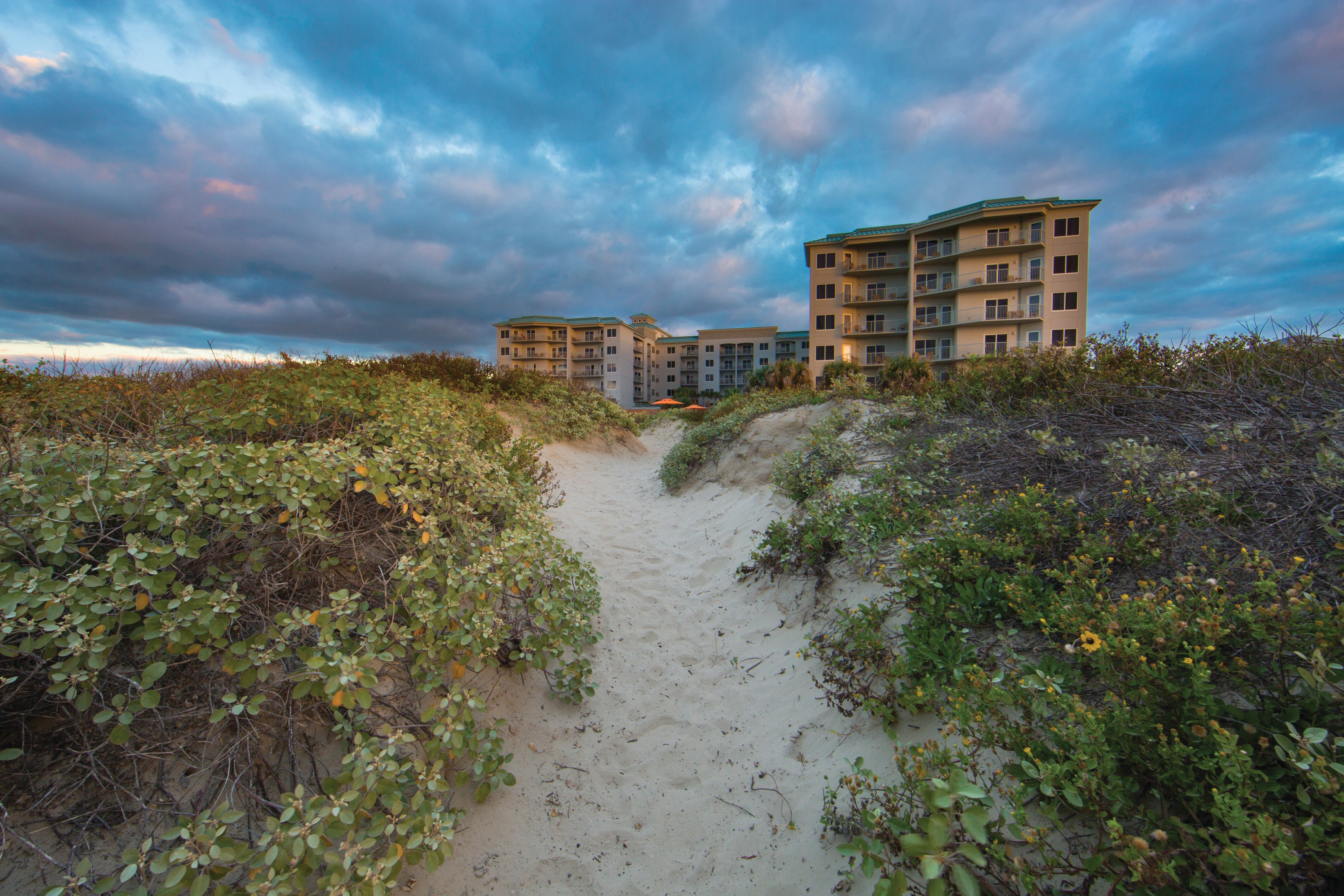 View of Galveston Beach Resort at sunset from the beach.