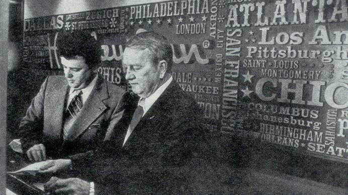 Kemmons Wilson working at a front desk in a Holiday Inn