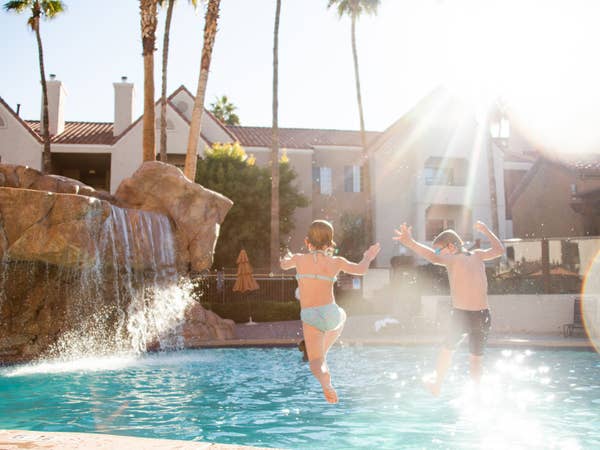 Two kids jumping into outdoor pool at Desert Club Resort in Las Vegas, Nevada.