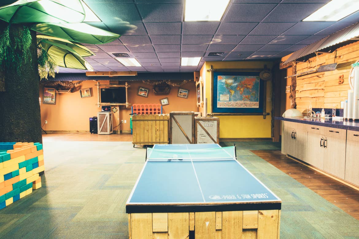 Activities room with ping pong table, life-sized Connect 4, and flat screen TV.
