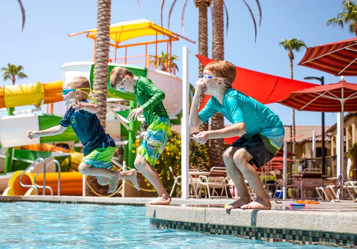 Three children jumping in pool in Splash Canyon water feature at Scottsdale Resort.