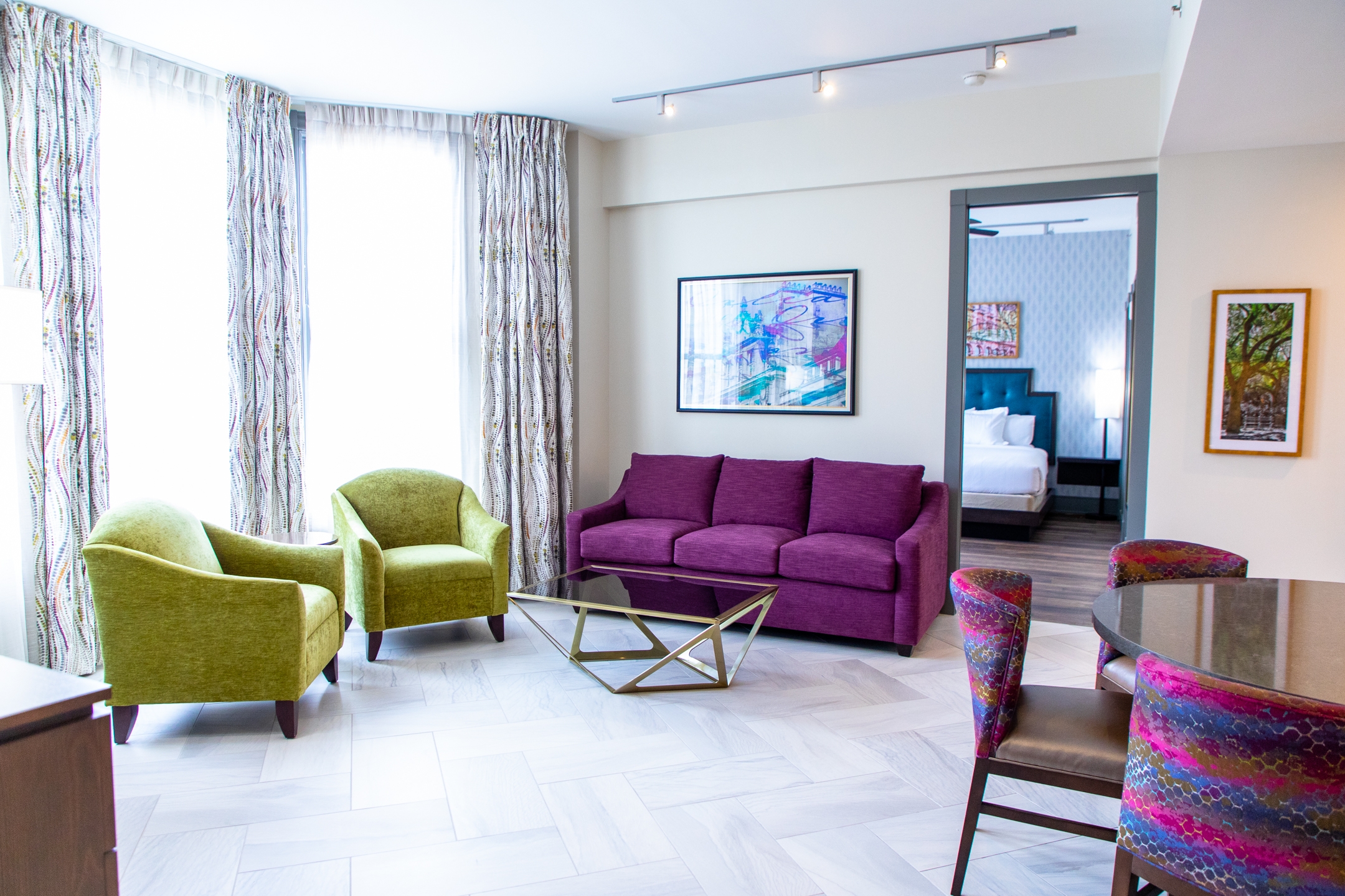 Signature Collection two bedroom villa living area with couch, two chairs and large window at New Orleans Resort in Louisiana.