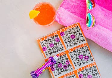 Bingo card with marker, sunglasses and drink.