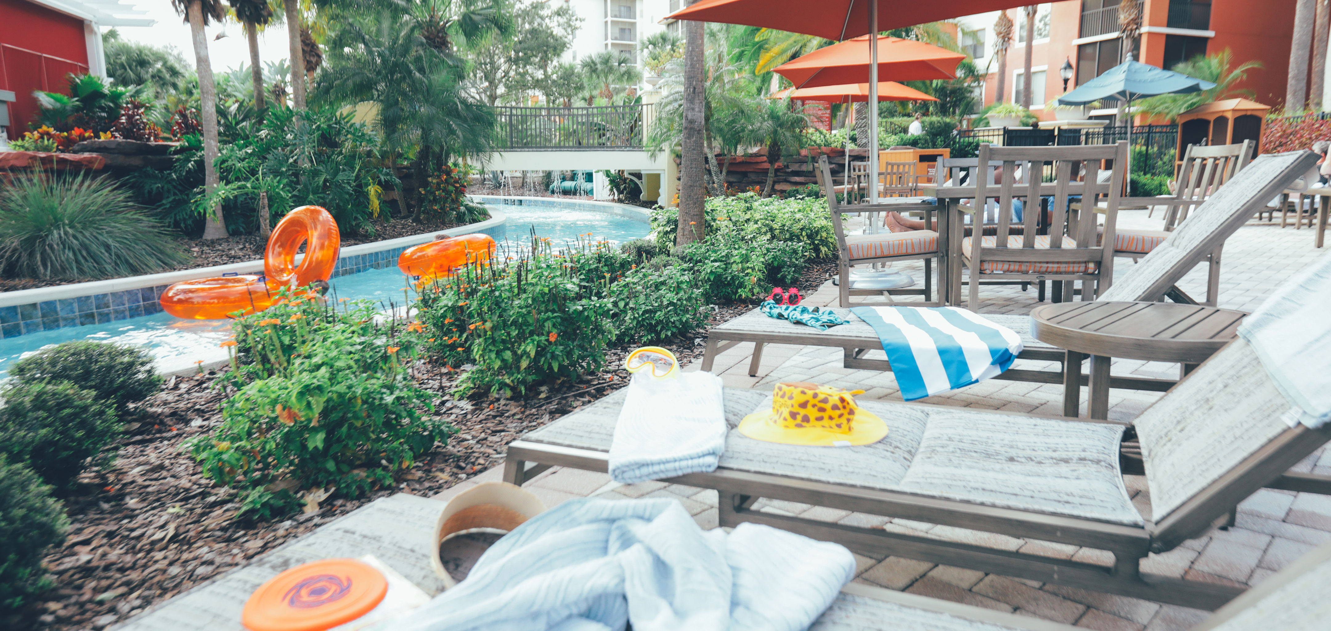 Beach chairs with swimming toys and towels placed next to our lazy river at Orange Lake Resort in Florida.