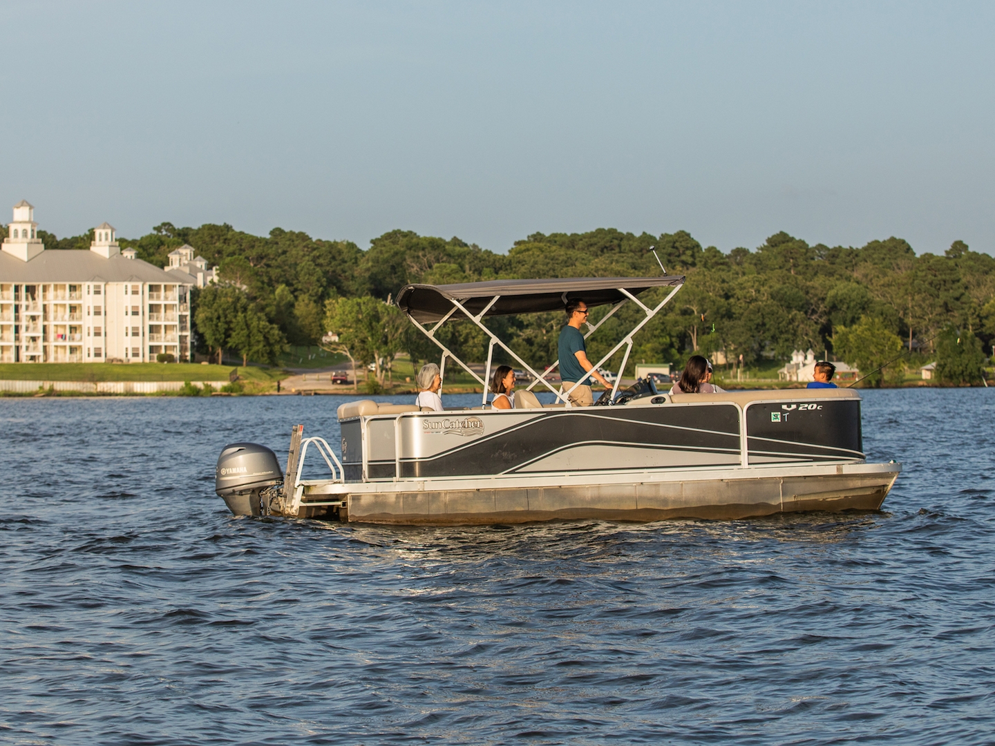 Family riding on pontoon boat at Villages Resort in Flint, Texas.