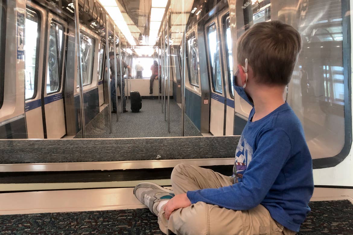 Sarah's son, Logan, sits on the bench of Orlando Airports terminal monorail.