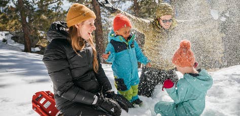 Dad throwing snow above two children on snowy mountain near Tahoe Ridge Resort in Stateline, Nevada.
