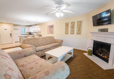 Living room with two couches and a fireplace in a two-bedroom presidential villa at Fox River Resort in Sheridan, Illinois.