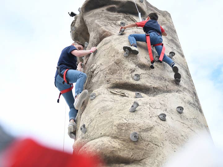 Two guests climbing on outdoor rock wall at Orange Lake Resort near Orlando, Florida.