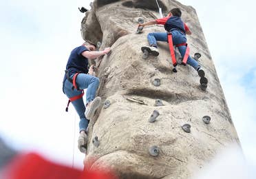 Two guests climbing on outdoor rock wall at Orange Lake Resort near Orlando, Florida.
