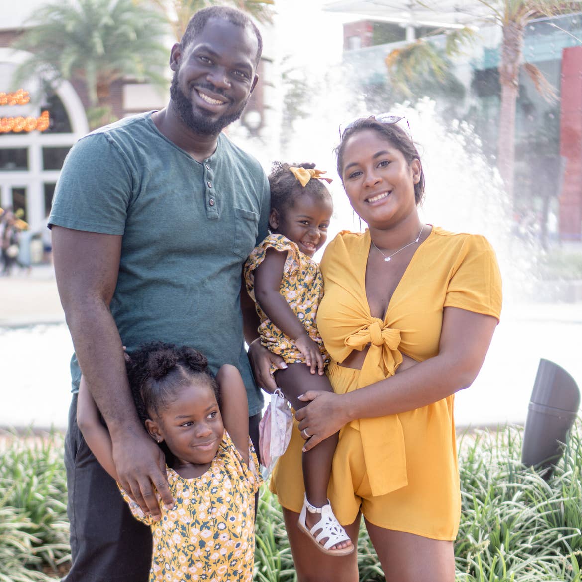 Author, Kimberly Gelin (top-right), poses with her family in front of a water fountain at Disney Springs in Walt Disney World Resort.