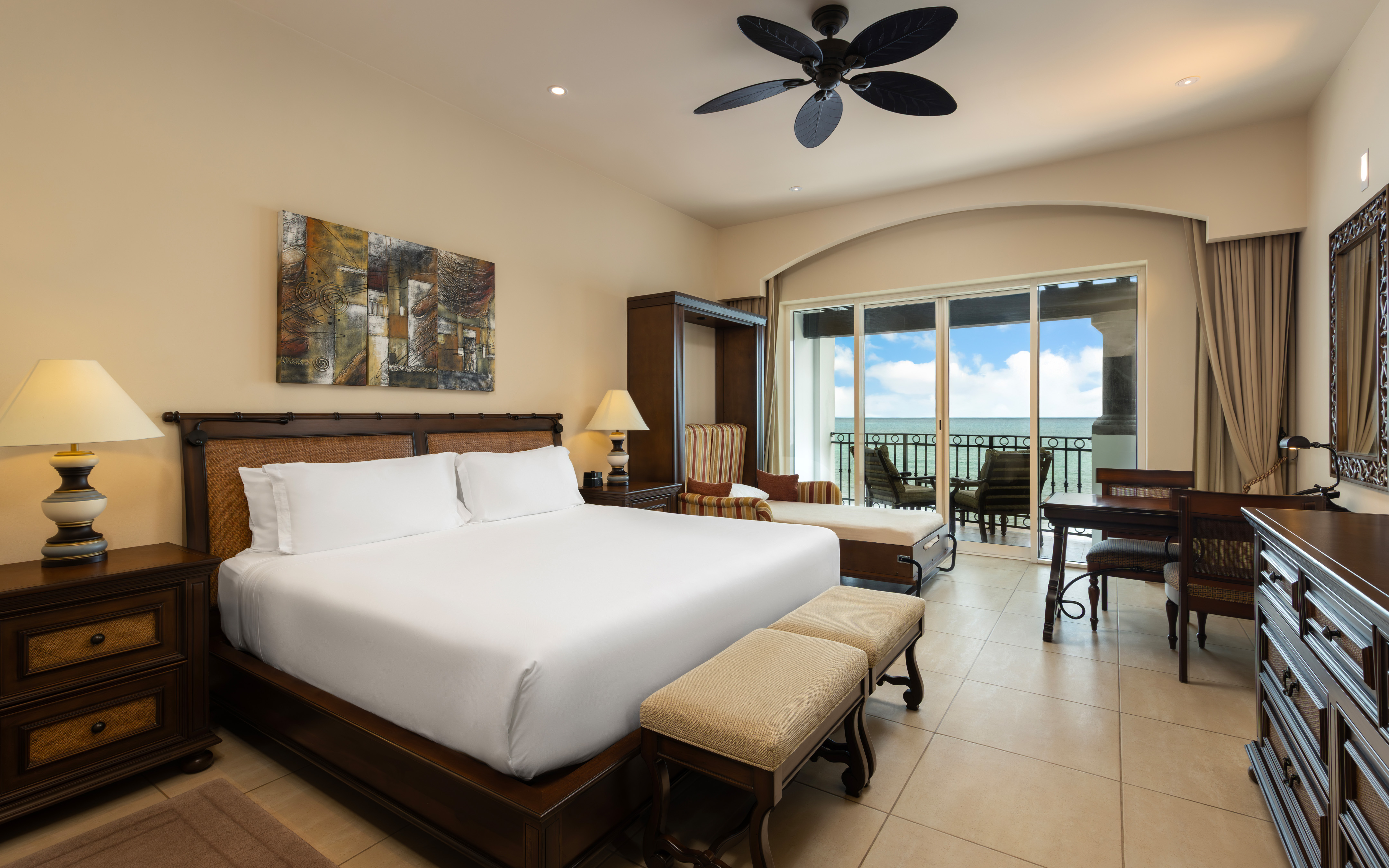 Oceanview king bedroom with seating area, daybed, and balcony.
