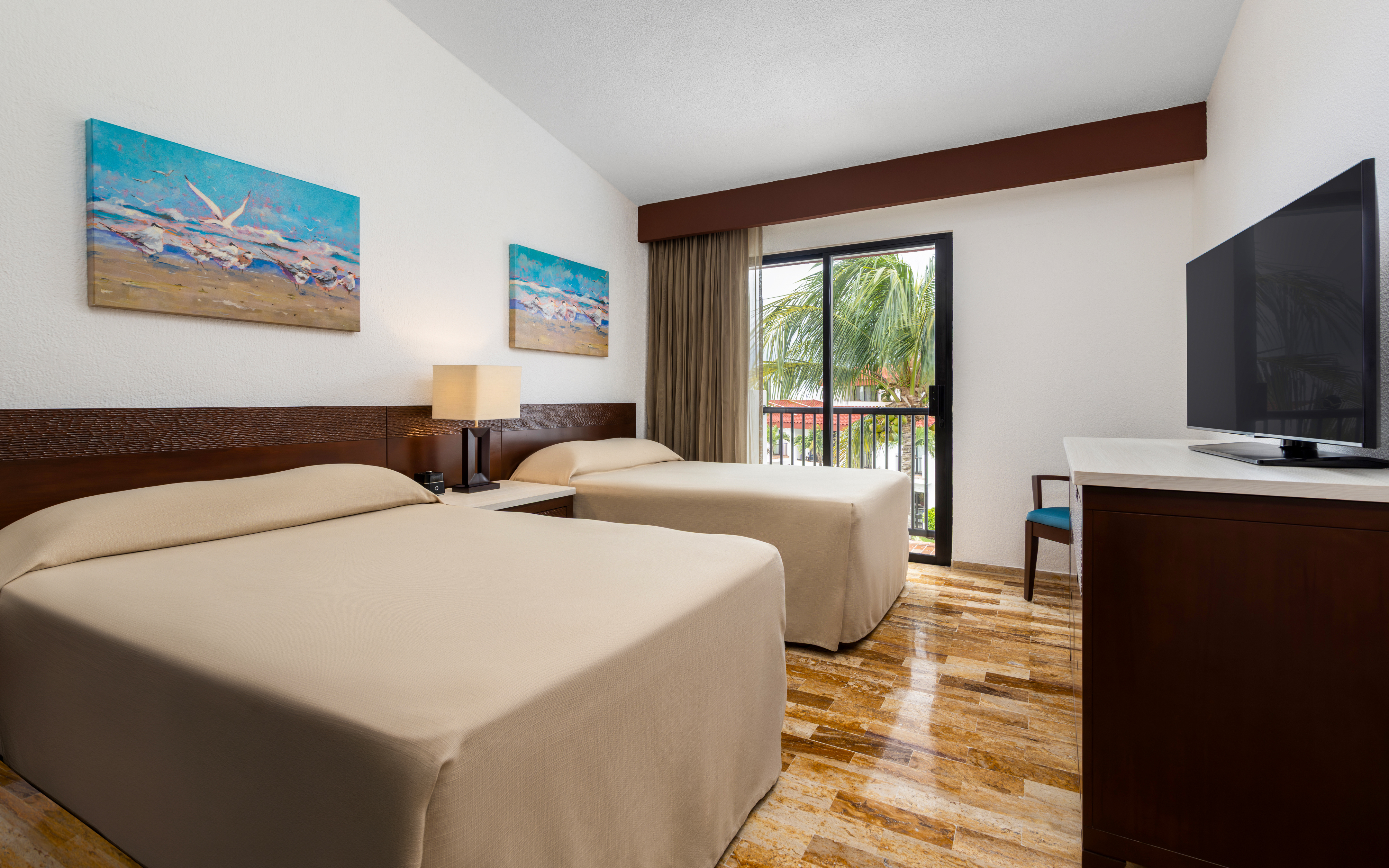 Modern bedroom with two twin beds, a window, and coastal artwork.