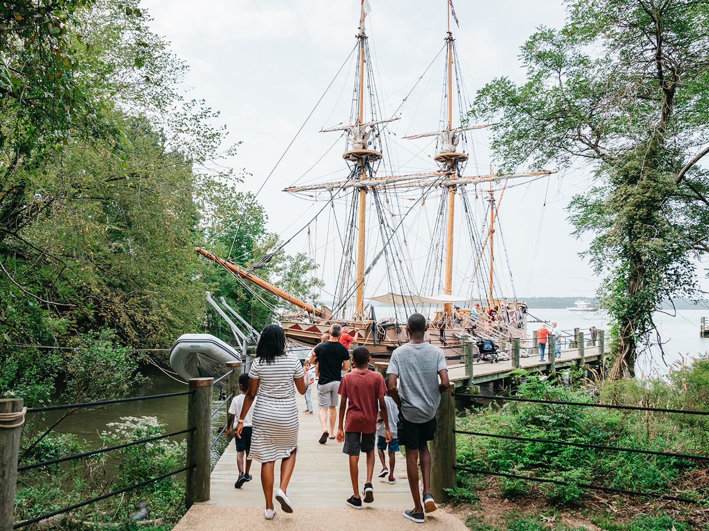 A family walks towards the Susan Constant ship at Jamestown Settlement in Williamsburg, Virginia.