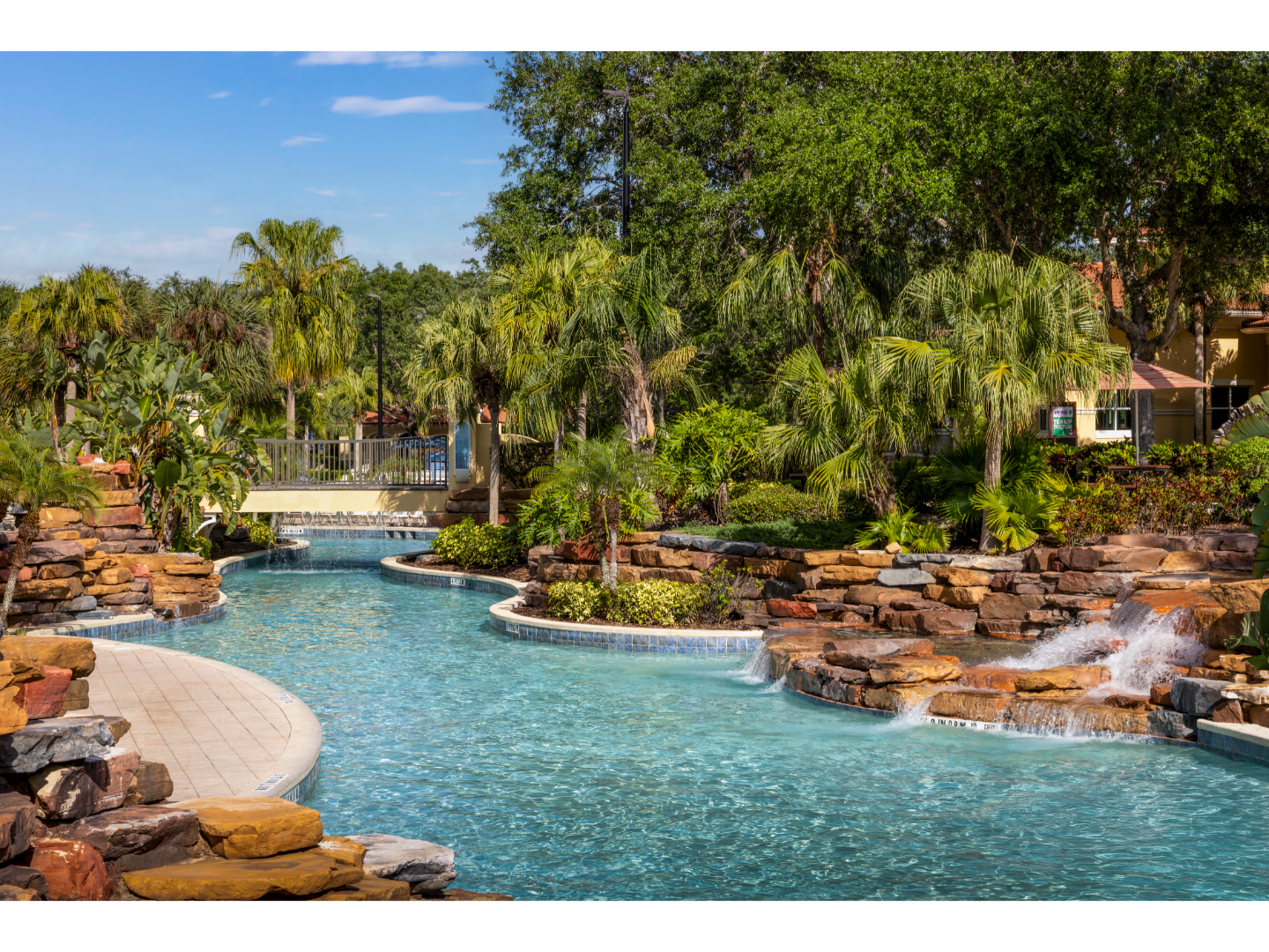 Lagoon-style pool surrounded by palm trees and waterfalls.