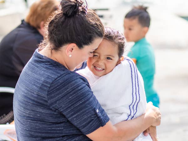 Adult hugging young child wrapped in towel by outdoor pool at Holiday Hills Resort in Branson, Missouri.