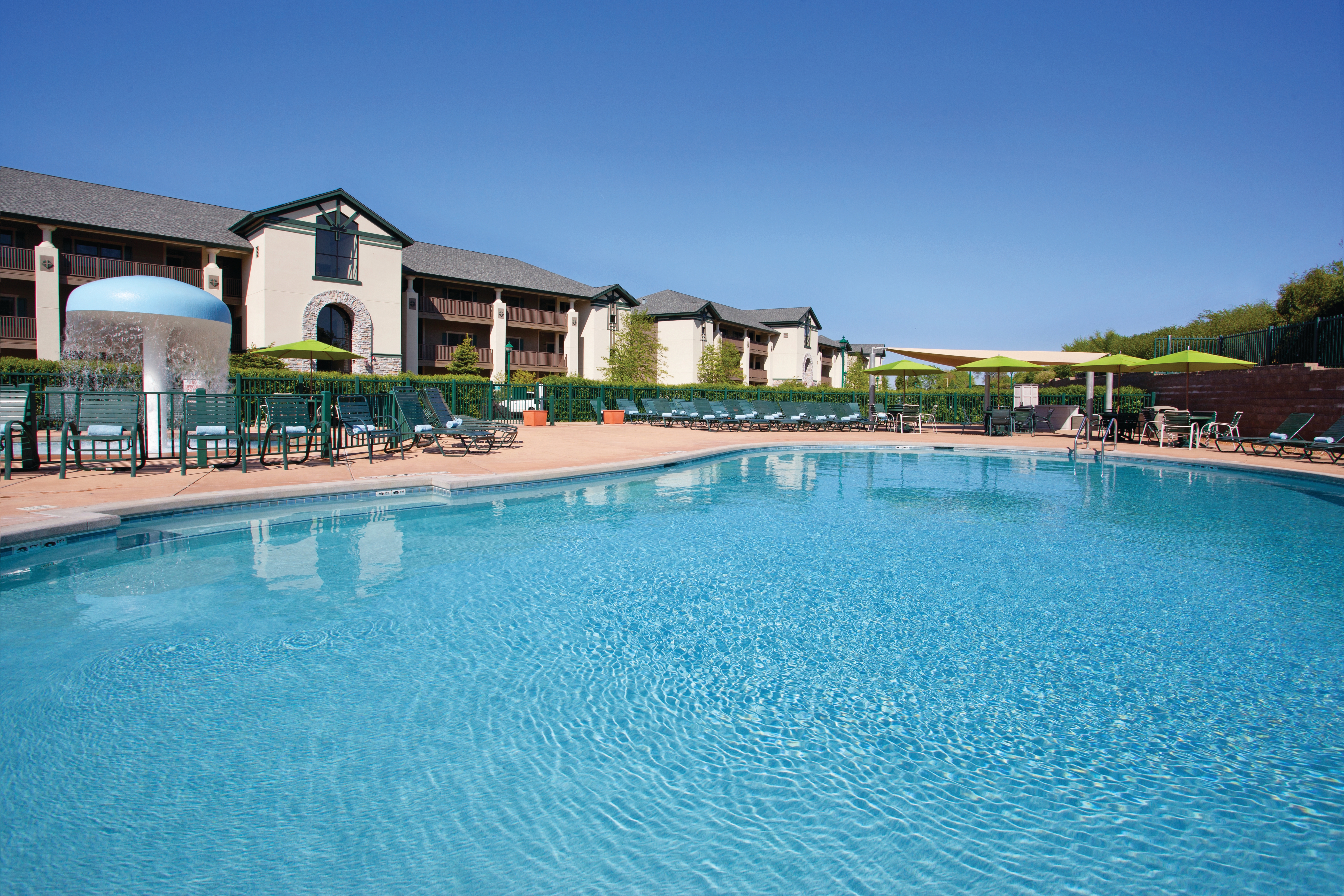 Outdoor pool with umbrellas and beach chairs at Lake Geneva Resort in Wisconsin.