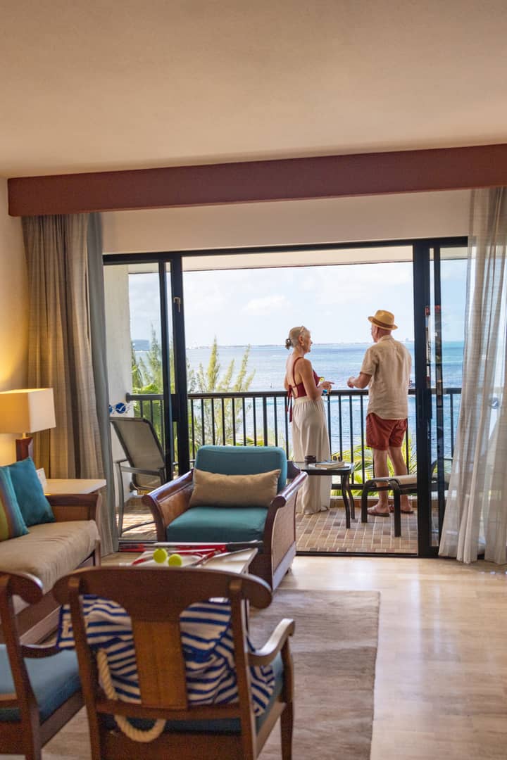 Older couple spending time on balcony overlooking ocean at Royal Cancun Resort in Mexico.
