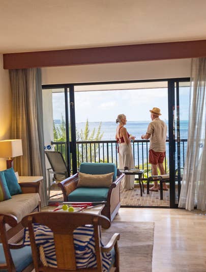 Older couple spending time on balcony overlooking ocean at Royal Cancun Resort in Mexico.