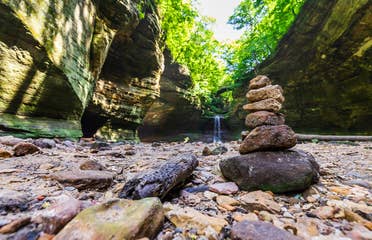 Pile of rocks stacked in front of a waterfall at Starved Rock State Park.