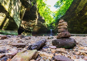 Pile of rocks stacked in front of a waterfall at Starved Rock State Park.