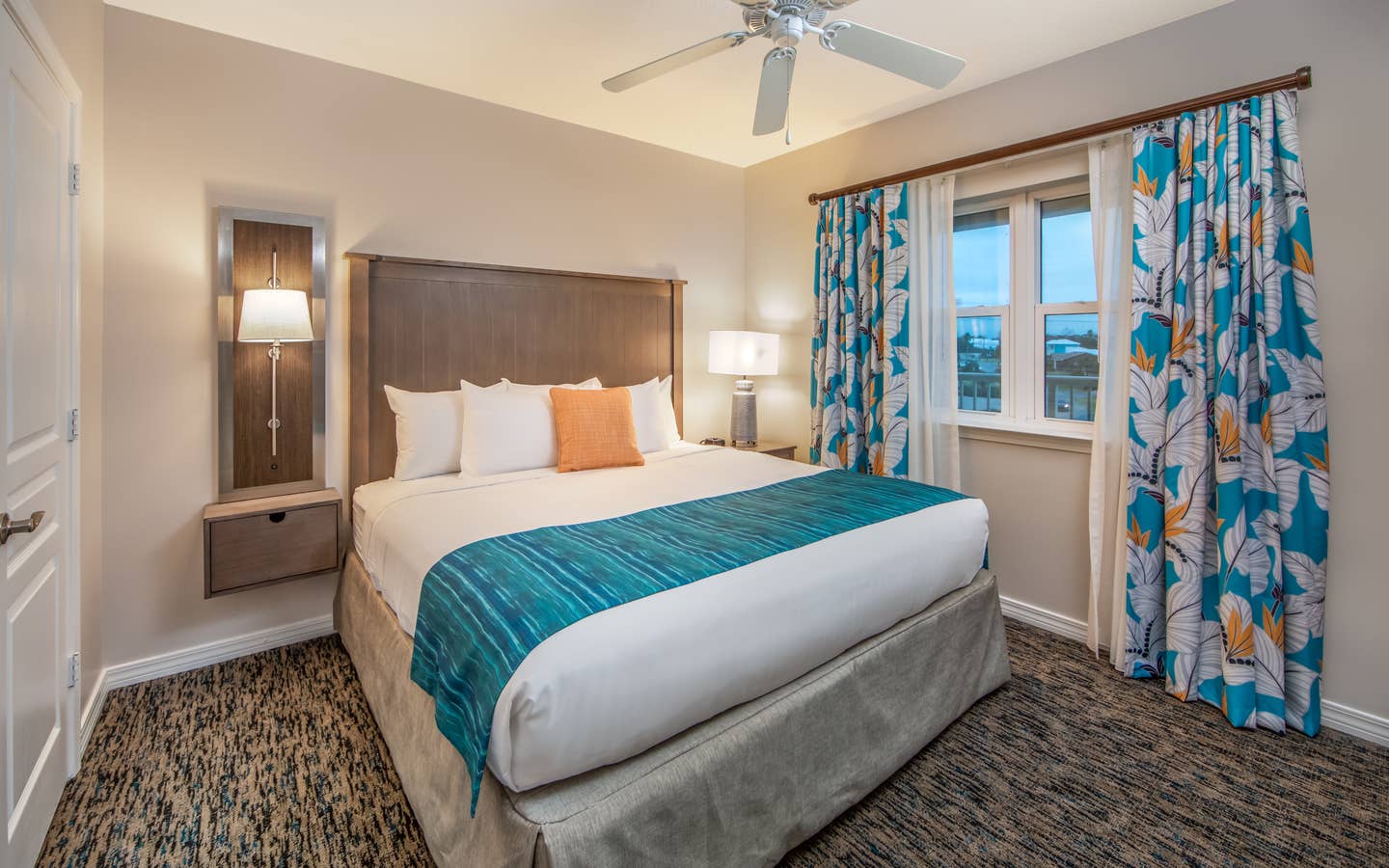 Bedroom with large window with view of ocean and ceiling fan in a two-bedroom villa at Panama City Beach Resort