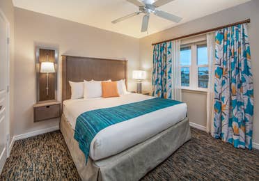 Bedroom with large window with view of ocean and ceiling fan in a two-bedroom villa at Panama City Beach Resort