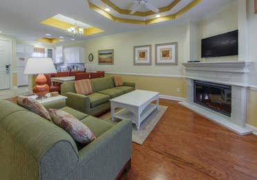 Living room with two couches, fireplace, and flat screen TV in a presidential villa at Fox River Resort in Sheridan, Illinois