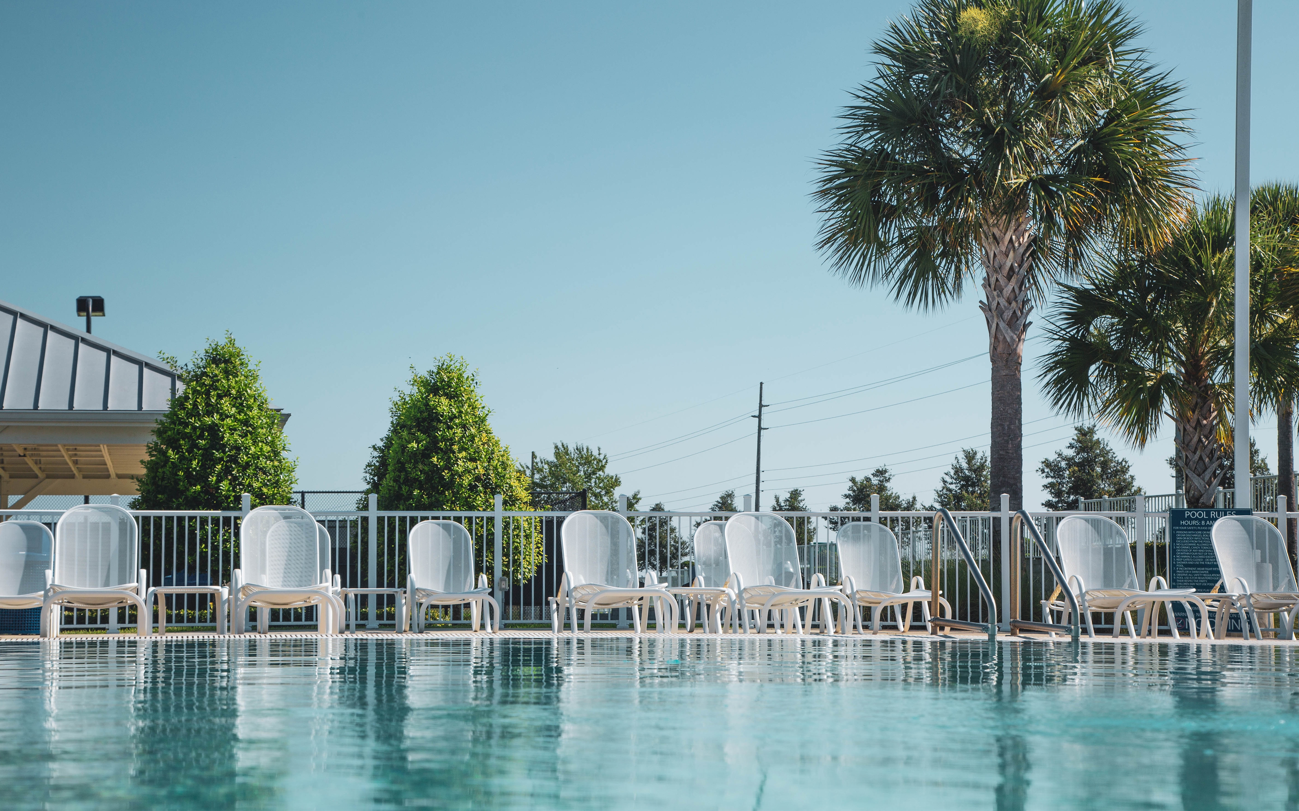 Pool chairs lined up at edge of outdoor pool at Orlando Breeze Resort in Florida.