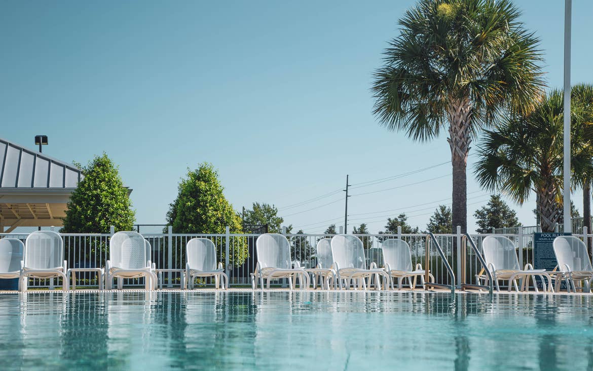 Pool chairs lined up at edge of outdoor pool at Orlando Breeze Resort in Florida.