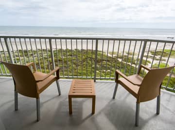 Furnished balcony with two chairs overlooking the beach in a two-bedroom villa at Galveston Beach Resort