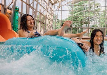 Two guests coming down waterslide in innertube at Waterpark at the Villages at Villages Resort in Flint, Texas.