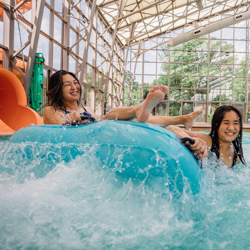 Two guests coming down waterslide in innertube at Waterpark at the Villages at Villages Resort in Flint, Texas.