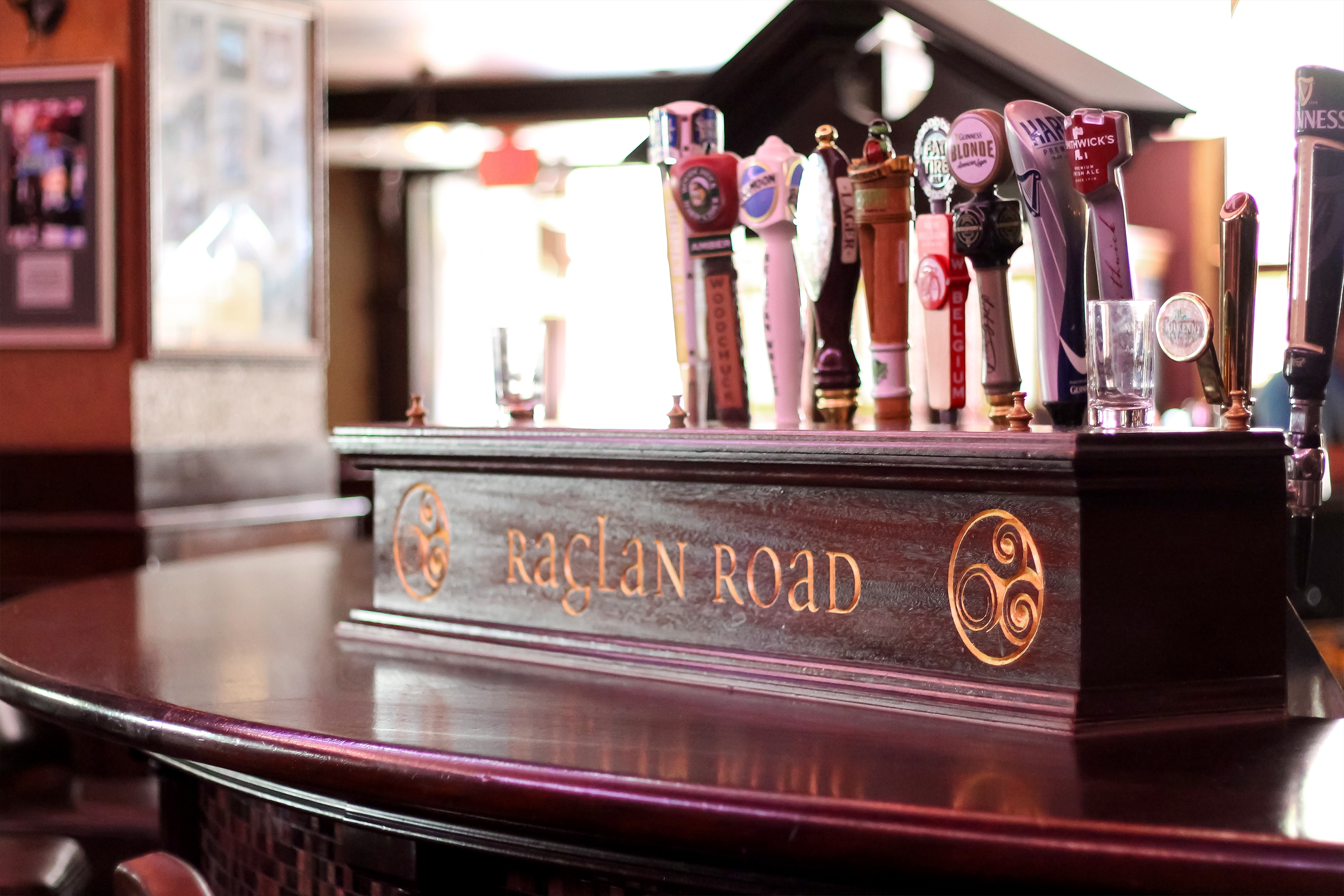 A wooden bar tap cover with ‘Raglan Road’ engraved on it.