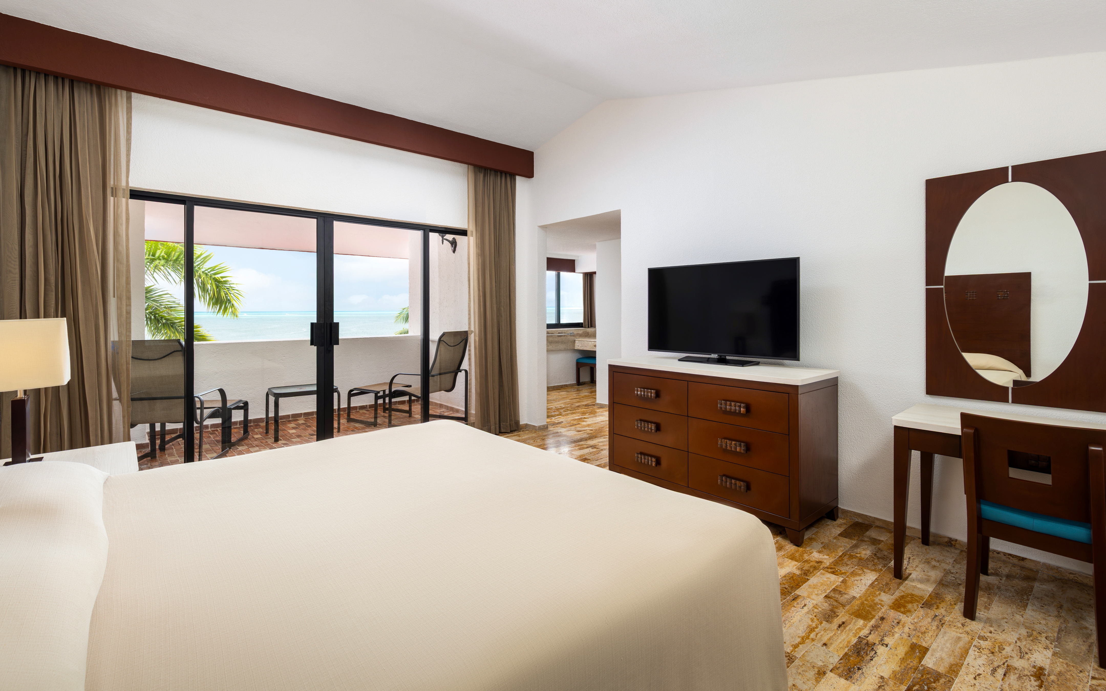 Oceanview villa bedroom with two beds and balcony access.