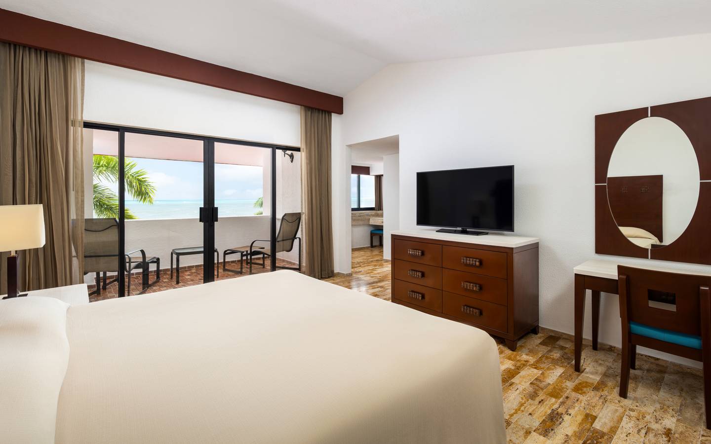 Oceanview villa bedroom with two beds and balcony access.