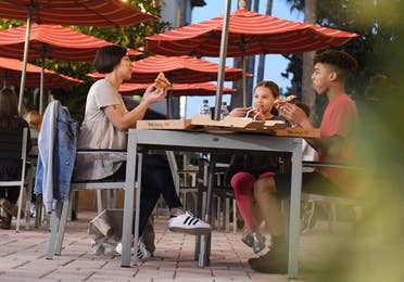 A group of people sitting outside of Paisan Pizzeria at Orange Lake Resort near Orlando, Florida.