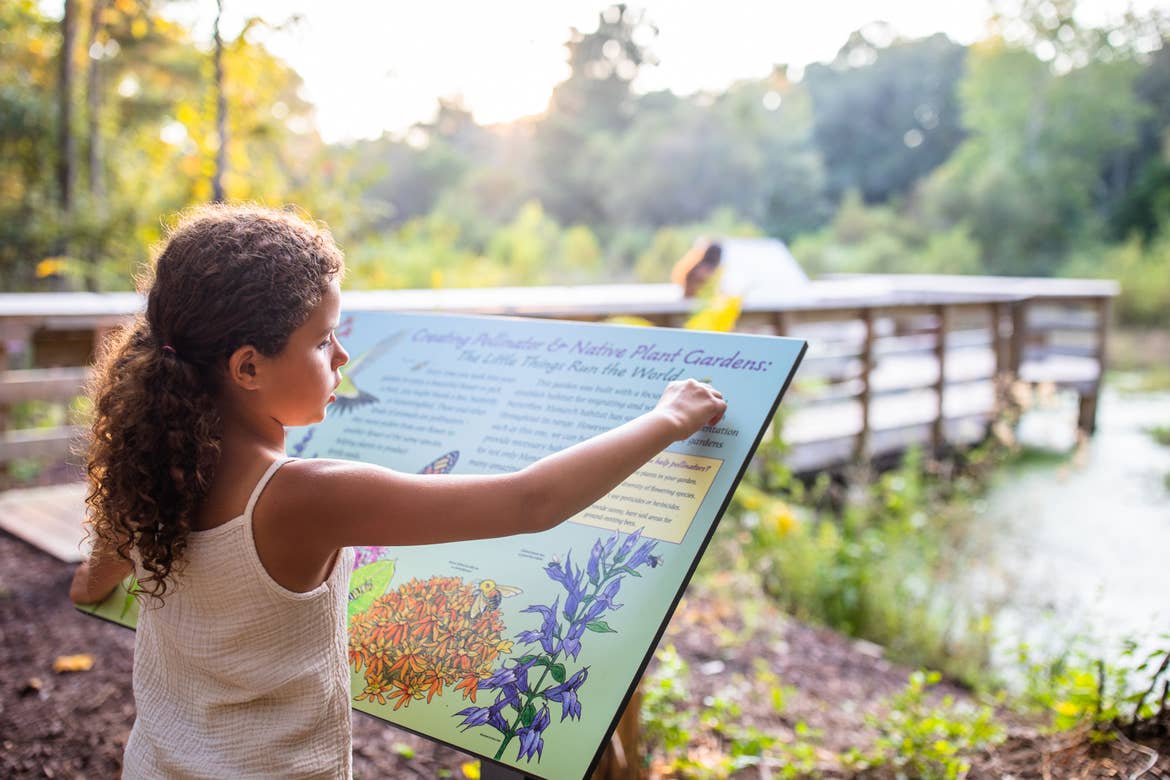 Author, Brenda Rivera Sterns' daughter reads an informational sign at Myrtle Beach State Park, South Carolina.