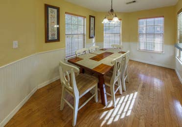 Dining table with six chairs in a presidential two bedroom villa at Piney Shores Resort in Conroe, Texas