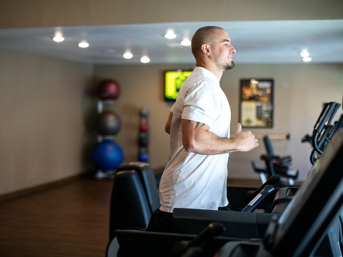 Man running on treadmill in fitness center at Desert Club Resort in Las Vegas, Nevada.