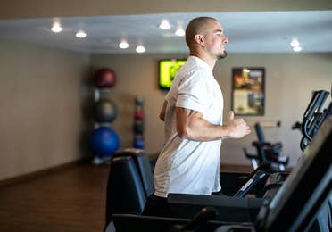 Man running on treadmill in fitness center at Desert Club Resort in Las Vegas, Nevada.