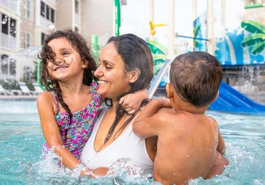 Mother holding two children in outdoor pool at South Beach Resort in Myrtle Beach, South Carolina.