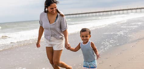Mother and son walking down beach holding hands at South Beach Resort in Myrtle Beach, South Carolina.