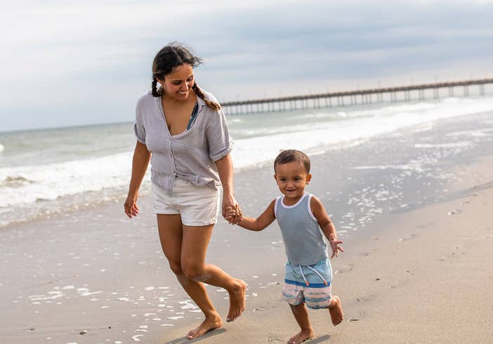 Mother and son walking down beach holding hands at South Beach Resort in Myrtle Beach, South Carolina.