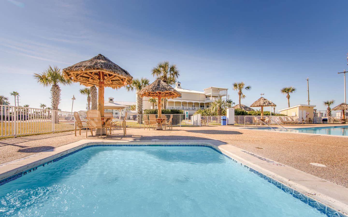 Outdoor pool surrounded by palm trees at Galveston Seaside Resort.