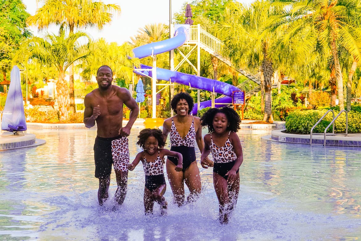 Featured Contributor, Monet Hambrick (center), and her husband (left) and two daughters (front) run through our pool at Orange Lake Resort located in Orlando, FL.
