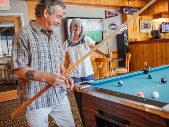 Two guests playing billiards in the Beartree Bar at Oak n' Spruce Resort in South Lee, Massachusetts.